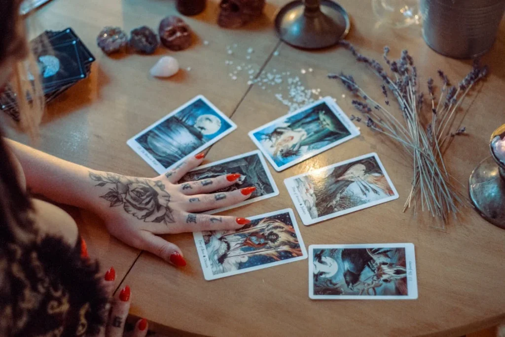 Lectura de tarot con cartas ilustradas sobre una mesa, acompañadas de piedras energéticas y elementos esotéricos.