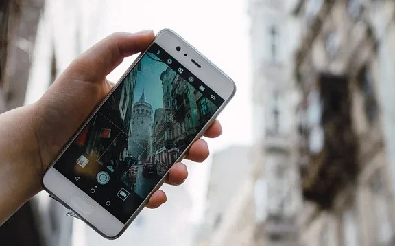 Turista usando un smartphone Android para hacer fotos durante un viaje por la ciudad