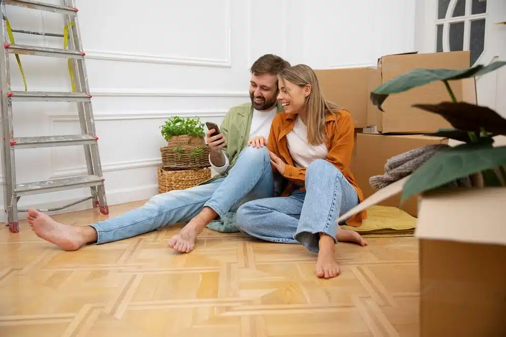 Pareja feliz usando aplicaciones Android para alquilar su nuevo piso