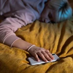 Persona dormida profundamente con el móvil tras usar aplicaciones Android para dormir