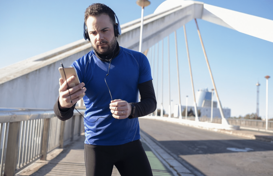 Hombre saliendo a hacer deporte mientras lo registra en las aplicaciones de su dispositivo Android