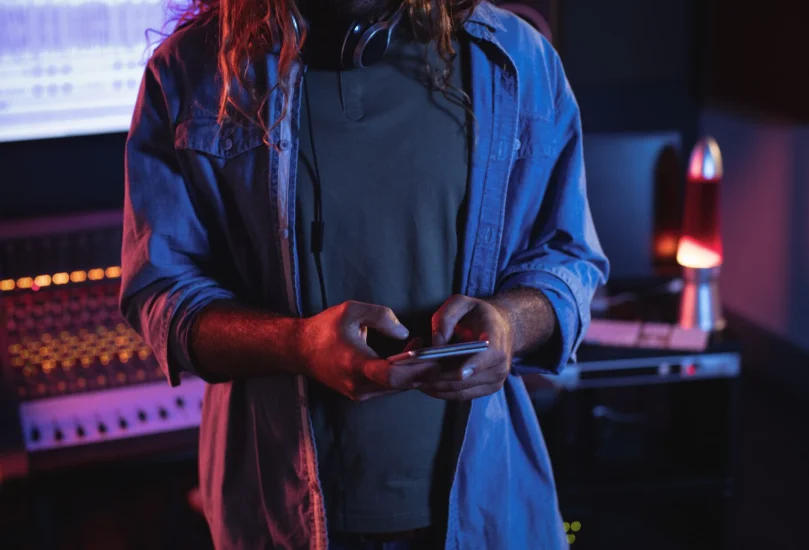 productor musical usando el móvil para crear y grabar canciones